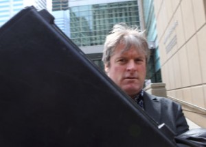 Robert Habermehl tries to avoid media by raising a briefcase as he leaves the Calgary Courts Centre April 30, 2013 in Calgary, Alta. Habermehl was charged in 2009 with causing an animal distress under the Animal Protection Act and a Criminal Code charges for injuring a cat. Jim Wells/Calgary Sun/QMI Agency